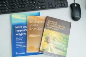 three books sitting on top of a desk next to a keyboard